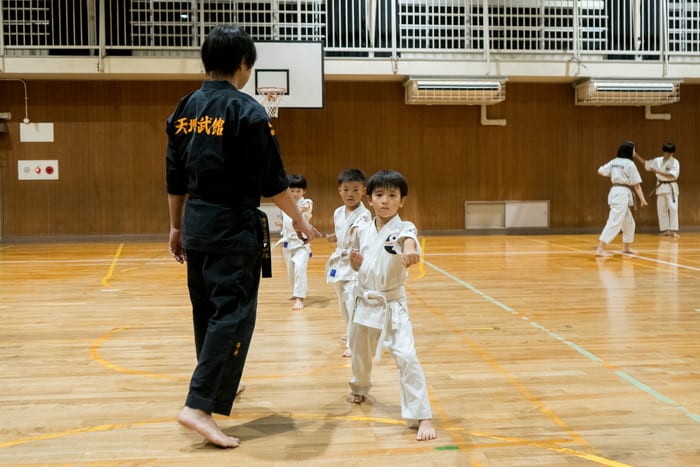 師範の後ろ姿と構えをとる道場生たち